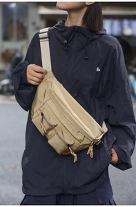 Detail of khaki nylon fanny pack with multi-zipper pockets and adjustable strap