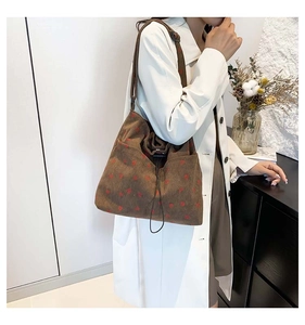 Detailed macro view of retro brown corduroy tote bag with red heart pattern and strap