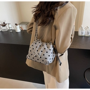 Detail of grey polka dot fabric bucket bag with silver chain strap and bow embroidery