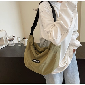Detail shot of green crescent canvas crossbody bag with adjustable wide strap for daily use