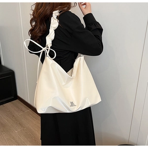 White glossy PU leather tote bag with pleated shoulder strap and side ribbon bow detail