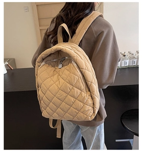 Detailansicht des gesteppten Puffer-Rucksacks in Khaki mit Metallreißverschlüssen