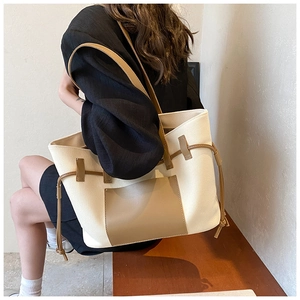 Lifestyle-Foto einer großen Canvas-Einkaufstasche mit braunen Lederakzenten und Kordelzug