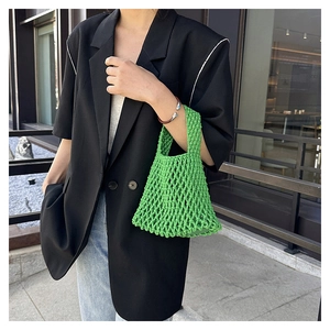 Close-up of bright green hand-woven mesh tote bag with minimalist hollow knit design