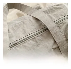Detail view of water-resistant wrinkled nylon fabric and reinforced stitching on the shoulder bag