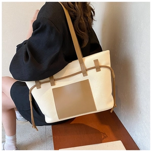 Canvas-Einkaufstasche mit brauner Ledertasche und Kordelzug am Modell getragen