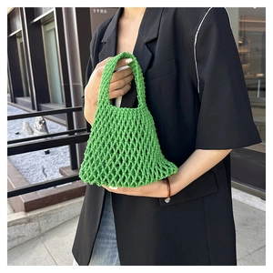 Close-up of grass green hand-woven tote bag with crochet mesh texture and sturdy handle