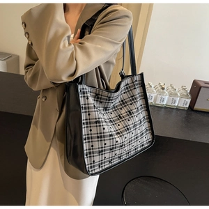 Close-up of large plaid tote bag with polka dots and synthetic leather stitching