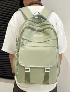 Détail d'un sac à dos en nylon vert clair avec boucles blanches et étiquette de mode