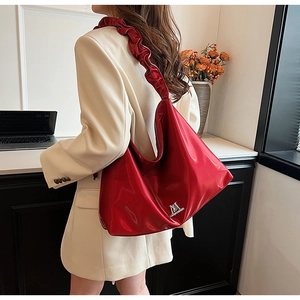 Detail of red PU leather tote bag with pleated strap and silver metallic logo