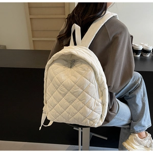 Detail des weißen gesteppten Nylon-Rucksacks mit Rautenmuster und Reißverschluss