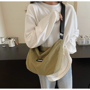 Olive green crossbody moon bag shown with wide adjustable strap for casual daily styling