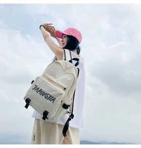 Detail view of a beige nylon backpack with DAPINGJIA print shown in an outdoor setting