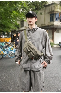 Detailed view of olive green tactical nylon chest bag with multiple functional pockets