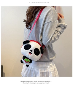 Detail of soft panda plush crossbody bag featuring strawberry charm and red strap