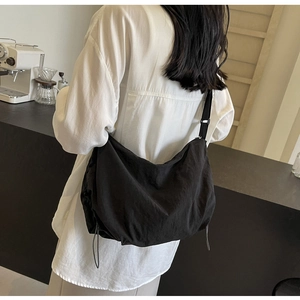 Detail of black large capacity hobo bag with adjustable strap and side drawstring features