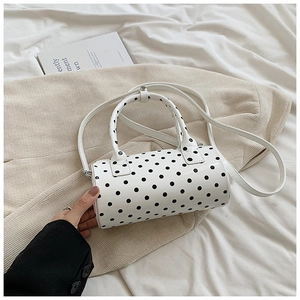 Chic white polka dot barrel bag in PU leather with dual ring handles and crossbody strap