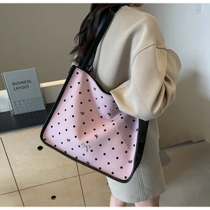 Pink polka dot tote bag with black leather trim and silver bow metal buckle detail