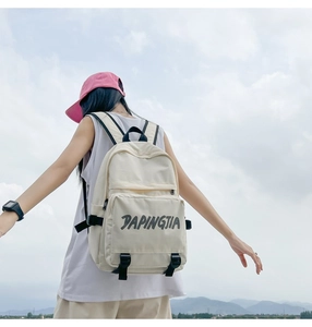 Outdoor model shot showing cream nylon backpack with PAPINGTIA logo and black straps
