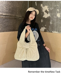 Vue détaillée du sac cabas en toile beige avec un grand nœud décoratif au design vintage