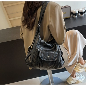 Close-up of black PU leather shoulder bag with lychee texture and adjustable wide strap