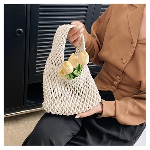 Detail of white hand-woven mesh tote bag with integrated handle for summer vacation