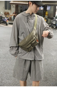 Close-up of olive green nylon fanny pack with multi-pockets and orange label detail