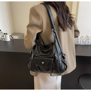 Detail view of black vintage oil wax PU leather shoulder bag with side zippers