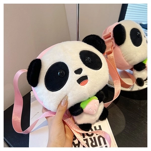 Detail of panda plush crossbody bag featuring soft faux fur and pink strawberry accessory