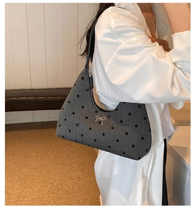 Dettaglio borsa in PU grigio a pois con trama twill e fiocco metallico argentato