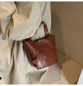 Détail du sac seau marron rétro en PU avec breloque étoile et attaches métalliques dorées