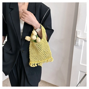 Detail of bright yellow hand-woven crochet handbag with stylish fringe and thick texture