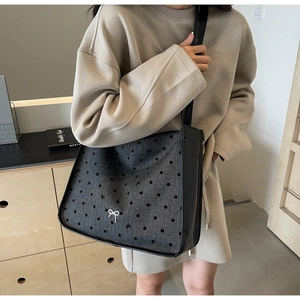Close-up of grey felt shoulder tote bag with black polka dots and small bow embroidery