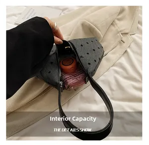 Vista dettagliata dell'interno di una borsa a tracolla grigia a pois con spazio compatto