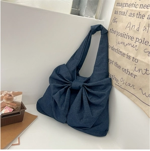 Détail d'un sac cabas en jean bleu avec un grand nœud décoratif pour le quotidien