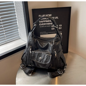 Modern black PU leather backpack with pleated texture and adjustable strap on metal table