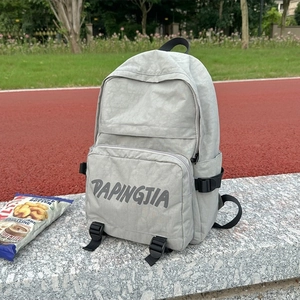 Light gray waterproof nylon backpack with front zipper pocket and adjustable straps