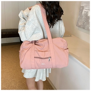 Pink nylon travel tote bag showing front zipper pocket and VEILA brand logo detail