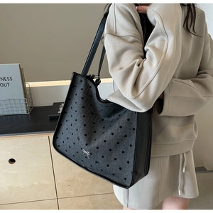 Close-up of gray felt tote bag with black polka dots and shoulder strap detail
