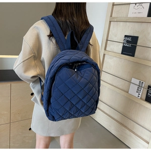 Detail des marineblauen gesteppten Nylon-Rucksacks mit Textur und gepolsterten Trägern