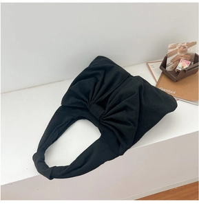 Détail du sac à main en denim noir avec un grand design plissé élégant en forme de nœud