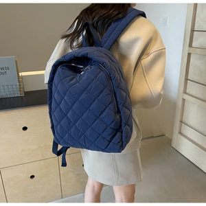Details des dunkelblauen gesteppten Nylon-Rucksacks mit Rautenmuster und Metallzippern