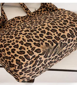 Close-up detail of leopard print canvas tote bag showing stitching and fabric texture