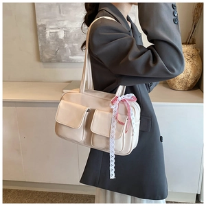 Chic cream white PU leather tote bag with lace ribbons shown on a model in a minimalist room