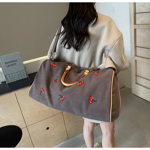 Large taupe travel tote with cherry embroidery and yellow handles for versatile daily use