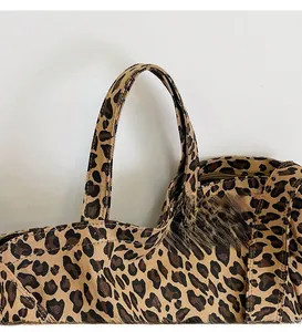 Close-up of leopard print canvas bag detailing wide strap and durable fabric texture