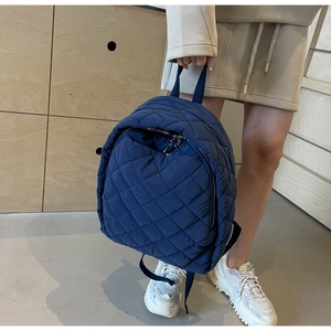 Detail eines dunkelblauen gesteppten Nylon-Rucksacks mit modischem Rautenmuster für Damen