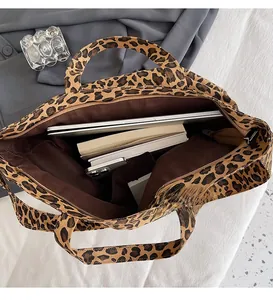 Spacious interior of leopard print canvas tote showing laptop and books storage
