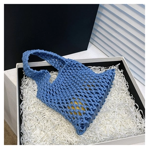 Blue woven crochet tote bag with textured mesh detail inside a premium gift box