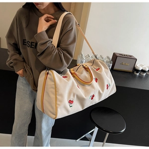 Detail of cherry print canvas tote bag with brown straps and detachable wide shoulder strap